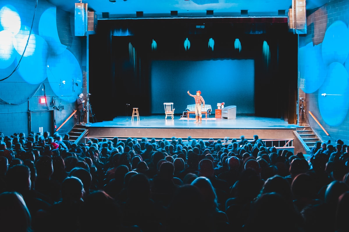 Comediant la show stand-up pe scenă cu microfon